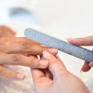 Woman in a nails salon receiving a manicure with nail file